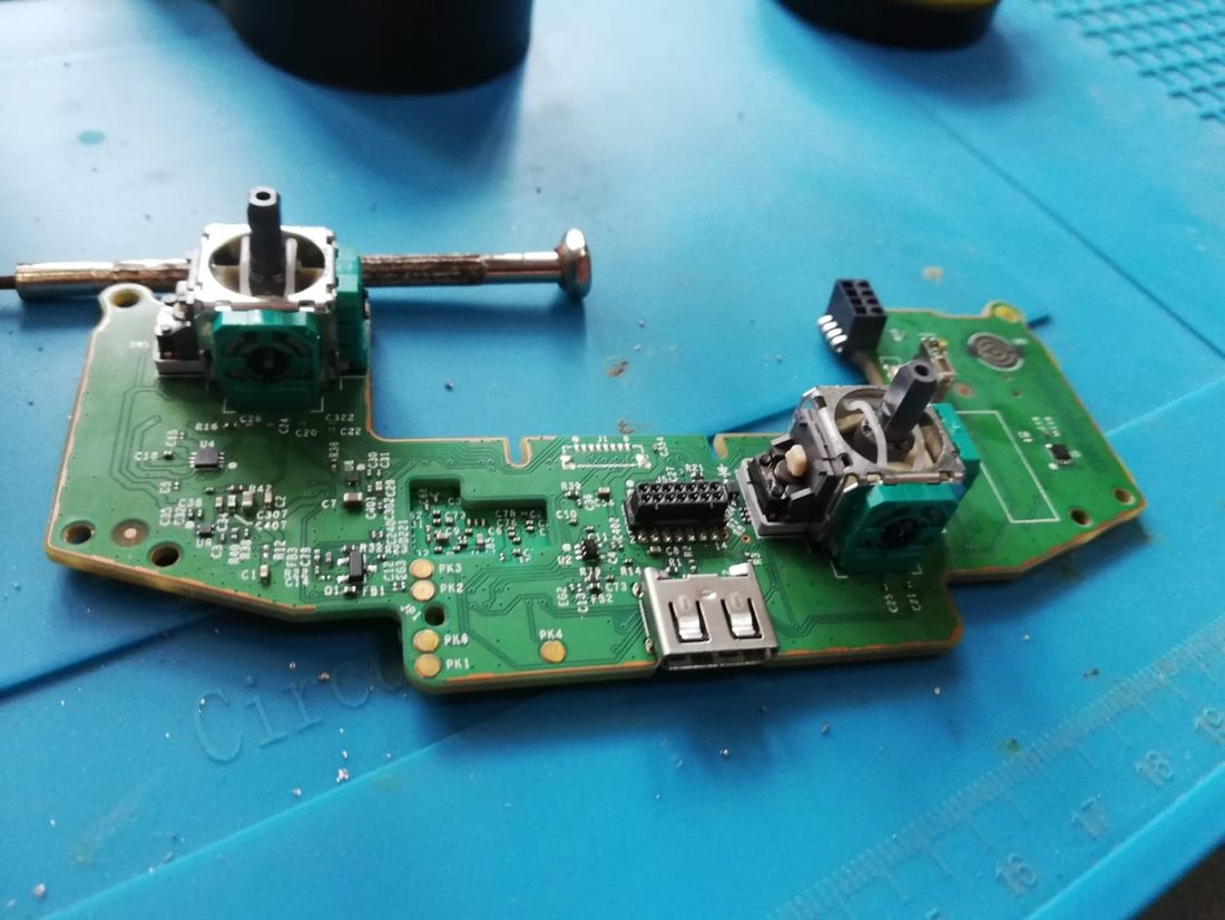 Controller teardown, with the worn potentiometer sticks desoldered from the board.